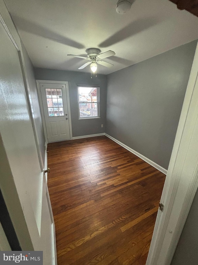 interior space featuring dark wood-type flooring and ceiling fan