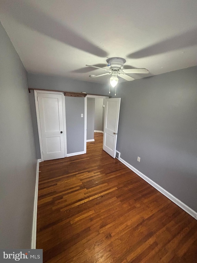 unfurnished bedroom with dark hardwood / wood-style flooring and ceiling fan