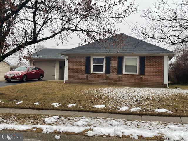 view of front of property with a garage, brick siding, driveway, and roof with shingles