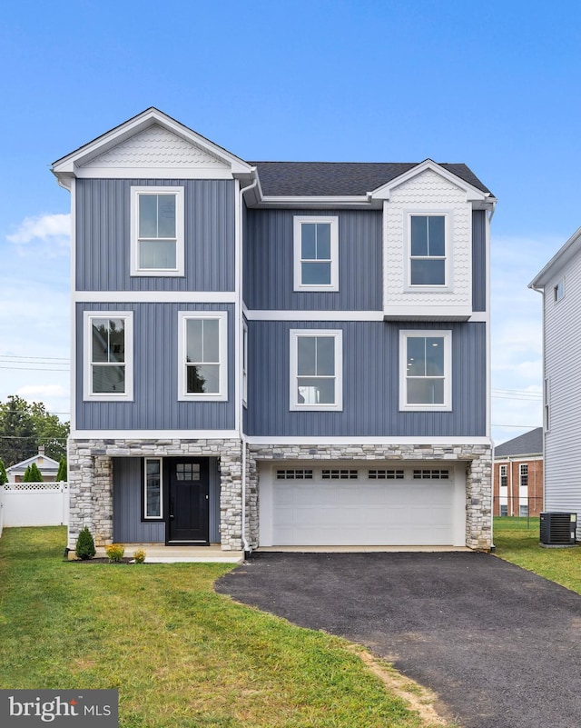 view of front of house with a garage, central AC, and a front lawn