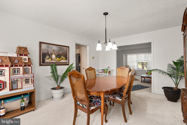 dining area with a chandelier and light carpet