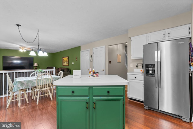 kitchen with stainless steel fridge, dark hardwood / wood-style flooring, a kitchen island, a notable chandelier, and white cabinets