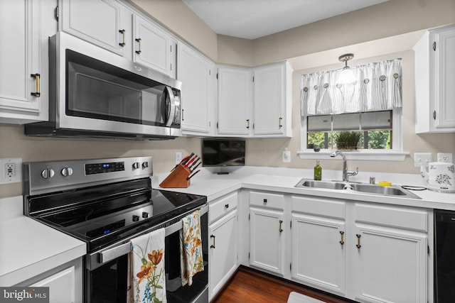 kitchen featuring stainless steel appliances, hanging light fixtures, sink, and white cabinets