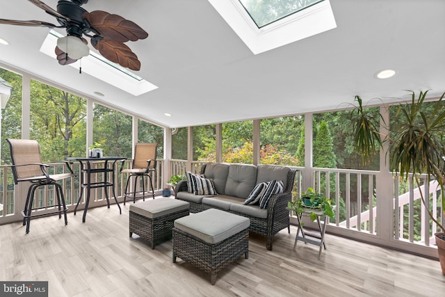 sunroom / solarium featuring vaulted ceiling with skylight and ceiling fan