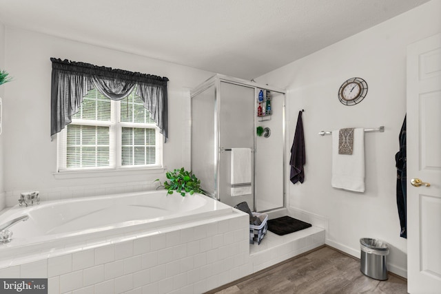 bathroom featuring hardwood / wood-style flooring and plus walk in shower