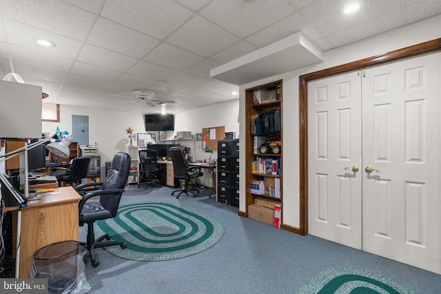 office space with a drop ceiling, electric panel, and carpet