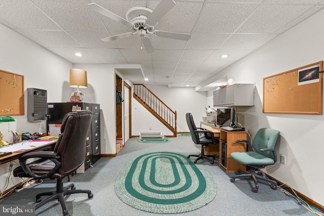 carpeted home office featuring a paneled ceiling and ceiling fan