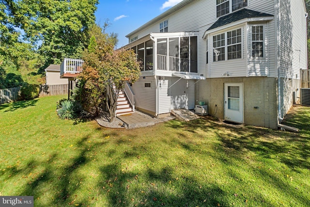 back of house with a sunroom and a lawn