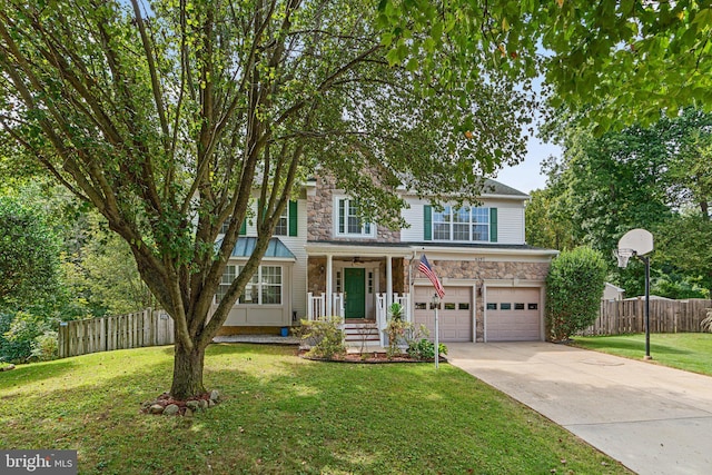 view of front of house featuring a garage, covered porch, and a front yard