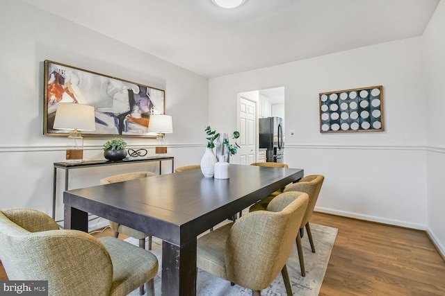 dining room featuring baseboards and wood finished floors