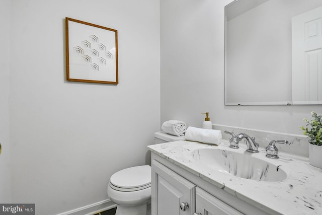 bathroom featuring vanity, toilet, and baseboards