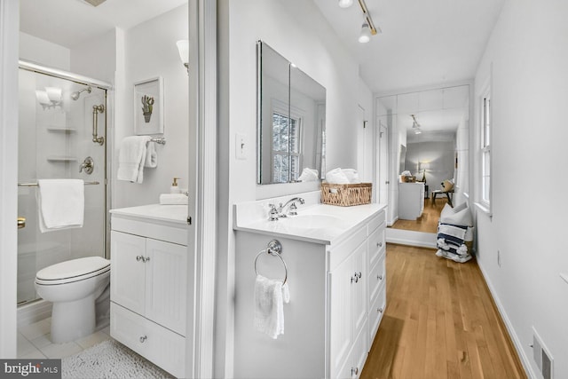 full bathroom featuring visible vents, toilet, wood finished floors, a shower stall, and vanity