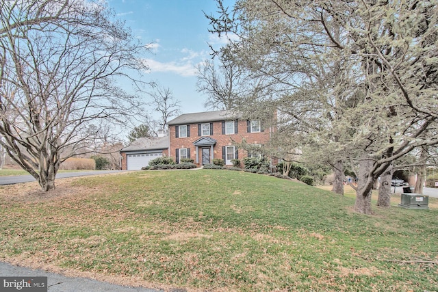 colonial-style house with brick siding, a garage, driveway, and a front yard