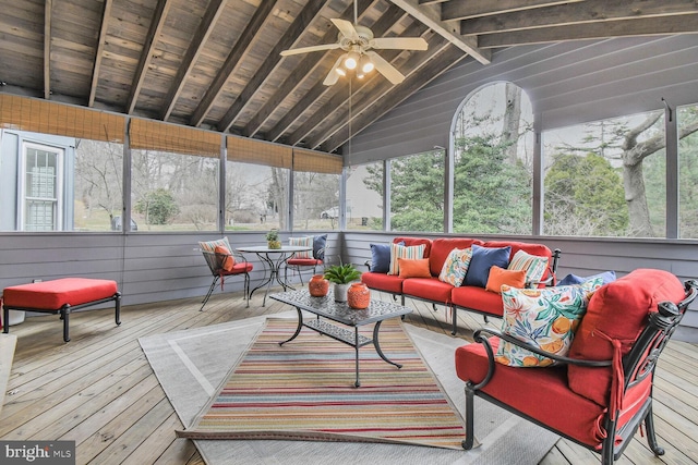 sunroom featuring lofted ceiling with beams and a ceiling fan