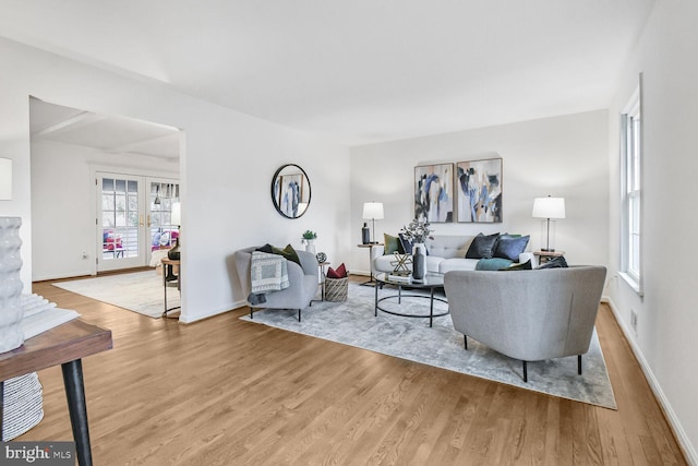 living room with french doors, light wood-type flooring, and baseboards