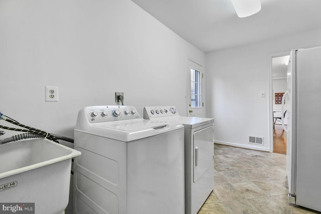 laundry room featuring visible vents, washer and dryer, a sink, baseboards, and laundry area