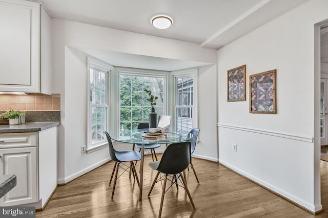 dining space with wood finished floors and baseboards