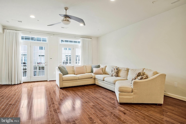 living room featuring baseboards, ceiling fan, visible vents, and wood finished floors