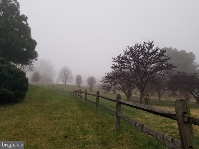 view of yard with a rural view and fence