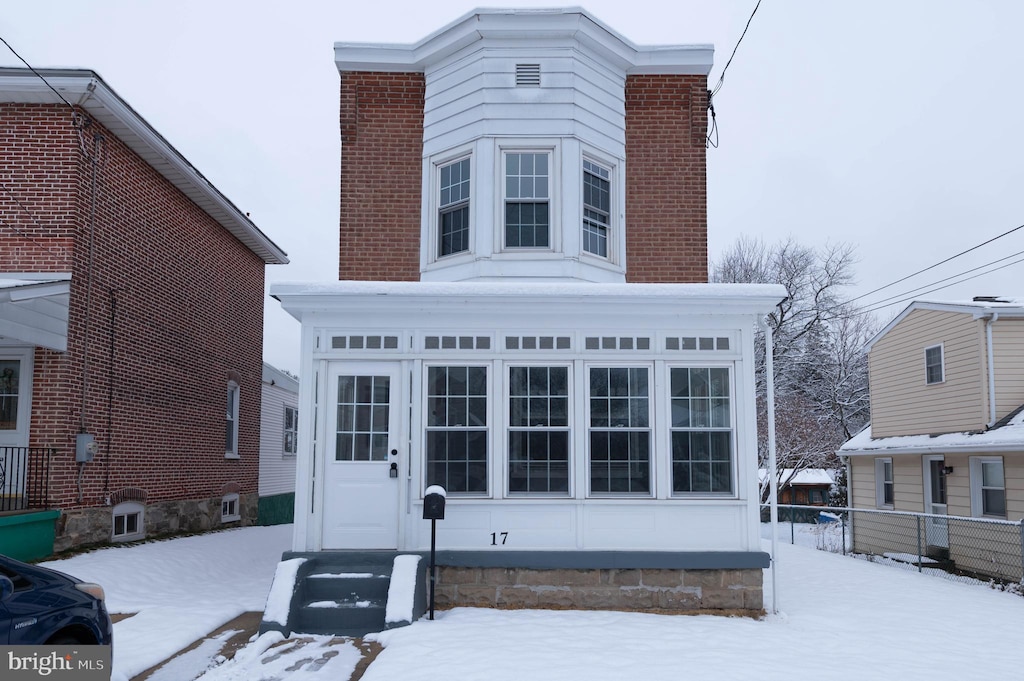 view of snow covered back of property