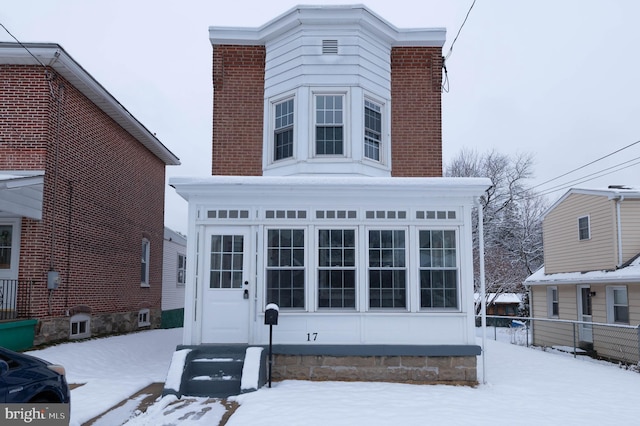 view of snow covered back of property