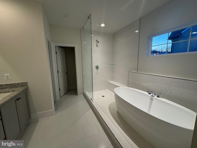 full bath featuring a stall shower, baseboards, a freestanding tub, and vanity