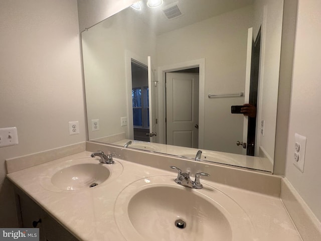 full bath featuring double vanity, visible vents, and a sink