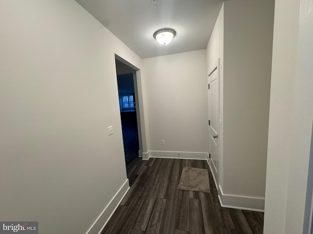 hallway with baseboards and dark wood finished floors