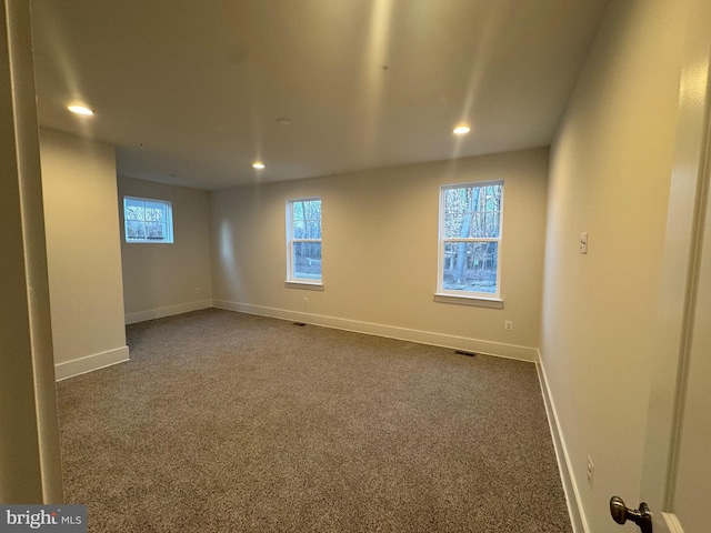 carpeted spare room with a wealth of natural light, baseboards, and recessed lighting