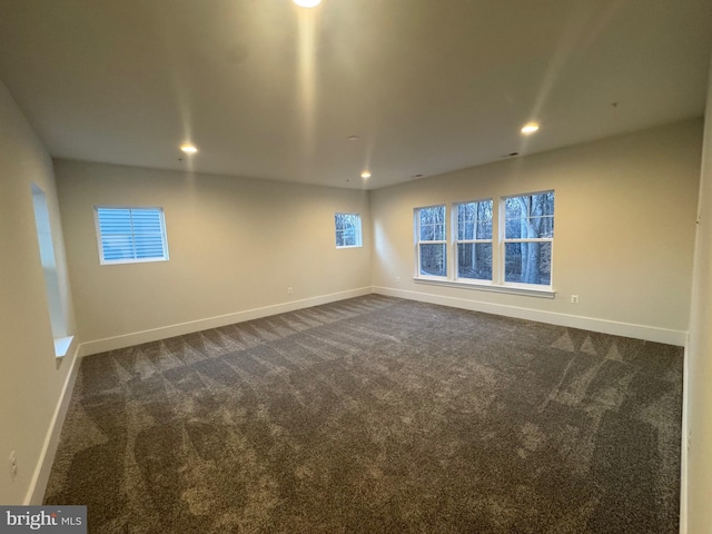 empty room with baseboards, dark carpet, and recessed lighting