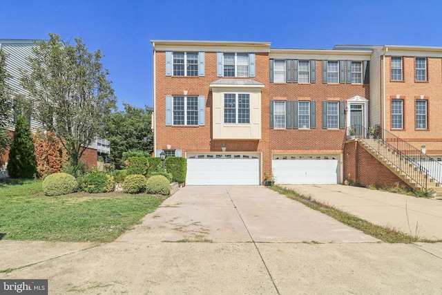 view of property featuring driveway, a garage, and brick siding