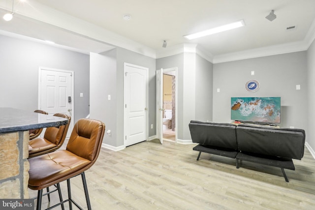 living area featuring ornamental molding, light wood finished floors, and baseboards