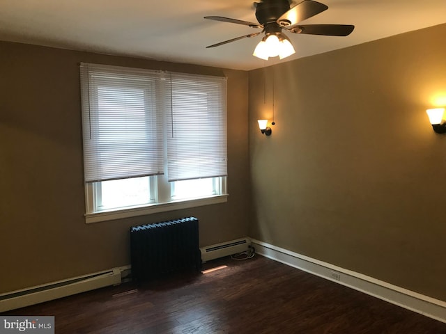 unfurnished room with ceiling fan, a baseboard heating unit, and dark hardwood / wood-style floors