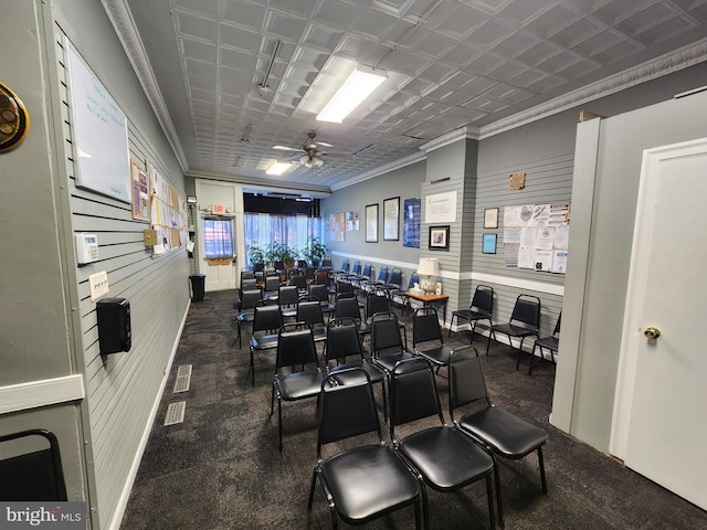 interior space with crown molding, wooden walls, and ceiling fan