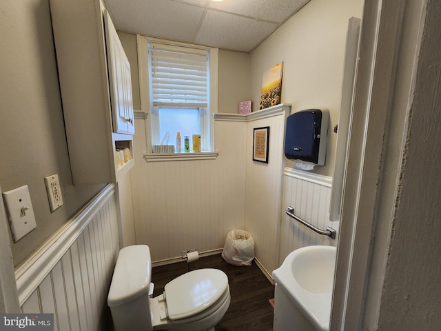 bathroom featuring hardwood / wood-style flooring, a drop ceiling, and toilet