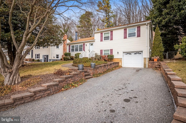 view of front facade featuring a garage, aphalt driveway, and a chimney