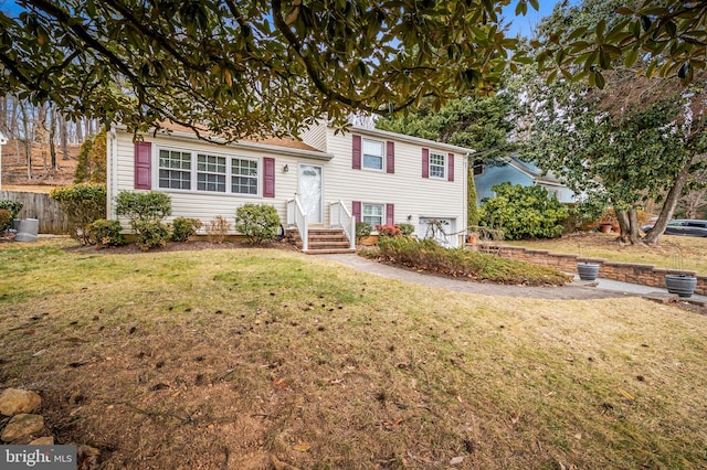 split level home with a garage, fence, and a front yard