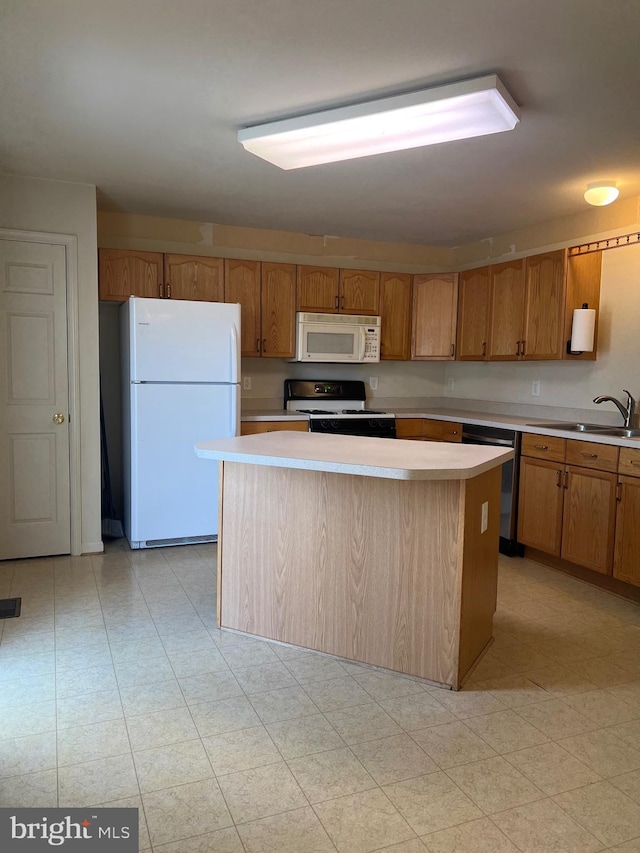 kitchen featuring sink, white appliances, and a center island