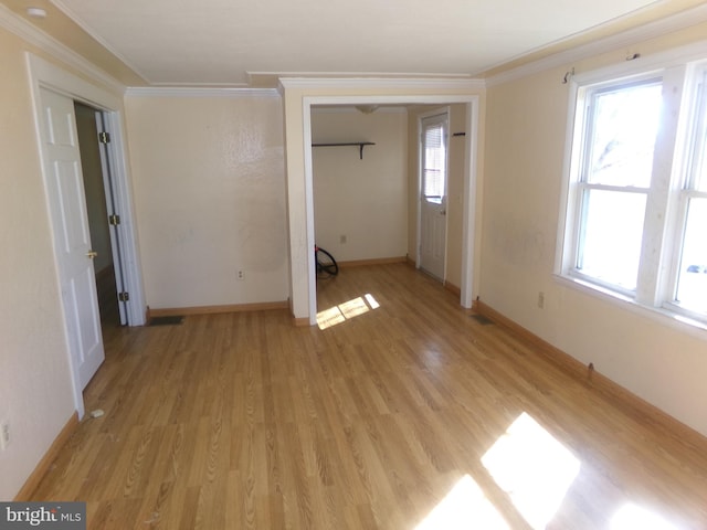 spare room with ornamental molding and light hardwood / wood-style floors