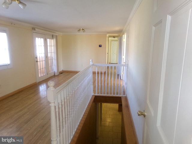 corridor with ornamental molding, hardwood / wood-style floors, and french doors