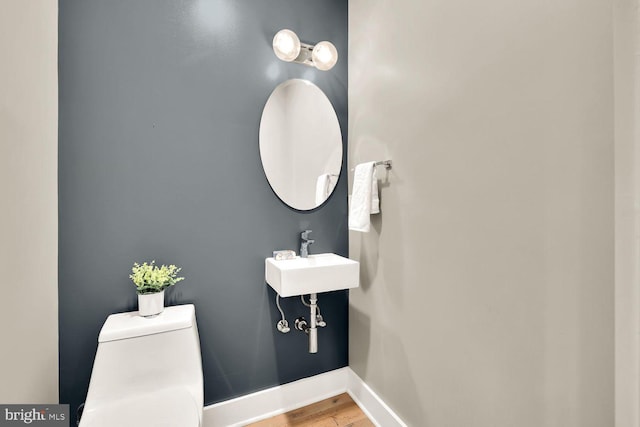 bathroom featuring sink, wood-type flooring, and toilet