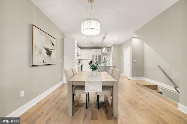 dining room with light hardwood / wood-style flooring and a chandelier