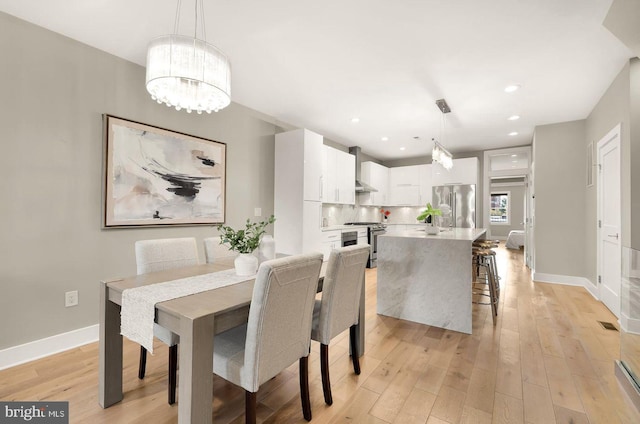 dining space with a chandelier and light wood-type flooring