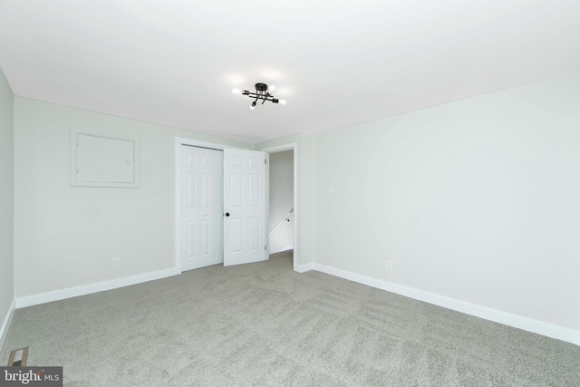 unfurnished bedroom featuring light carpet and a closet