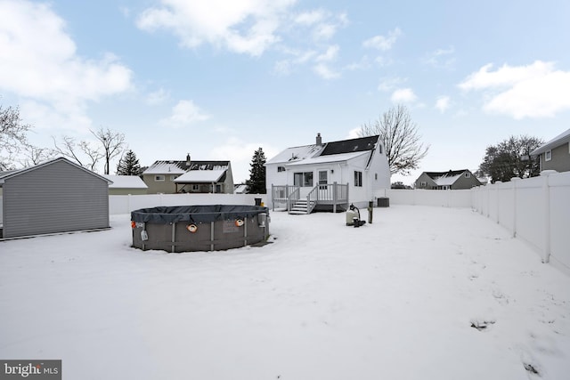 snow covered rear of property featuring a pool side deck