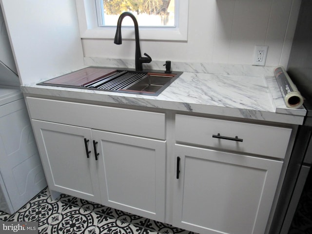 kitchen featuring light countertops, white cabinetry, and a sink