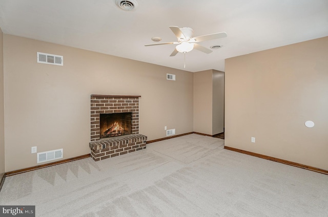 unfurnished living room featuring a brick fireplace, light carpet, and ceiling fan