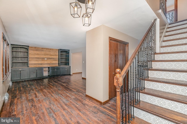 staircase featuring wood-type flooring and built in features