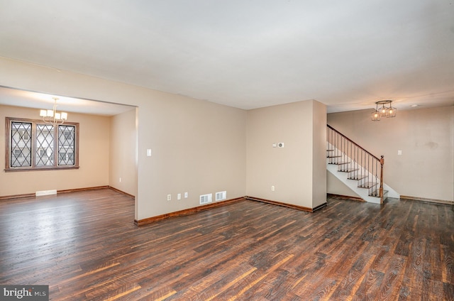 unfurnished living room featuring dark wood-type flooring and a chandelier