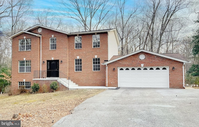 view of front of property featuring driveway, brick siding, and an attached garage